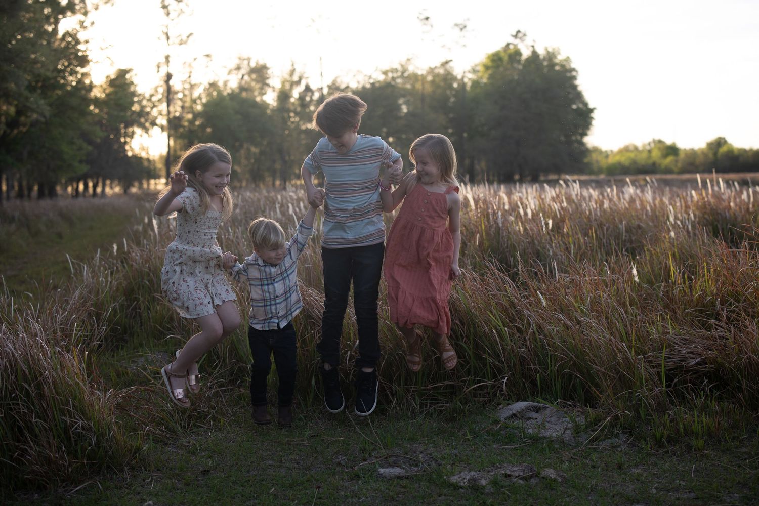 Lakeland Family photographer- kids jumping in field