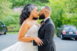 Elegant wedding couple sharing a romantic moment in an outdoor garden setting.
