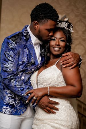 Elegant wedding portrait with couple in blue and white attire sharing a tender moment.