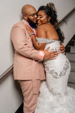 Intimate wedding portrait with couple in peach suit and white lace dress.