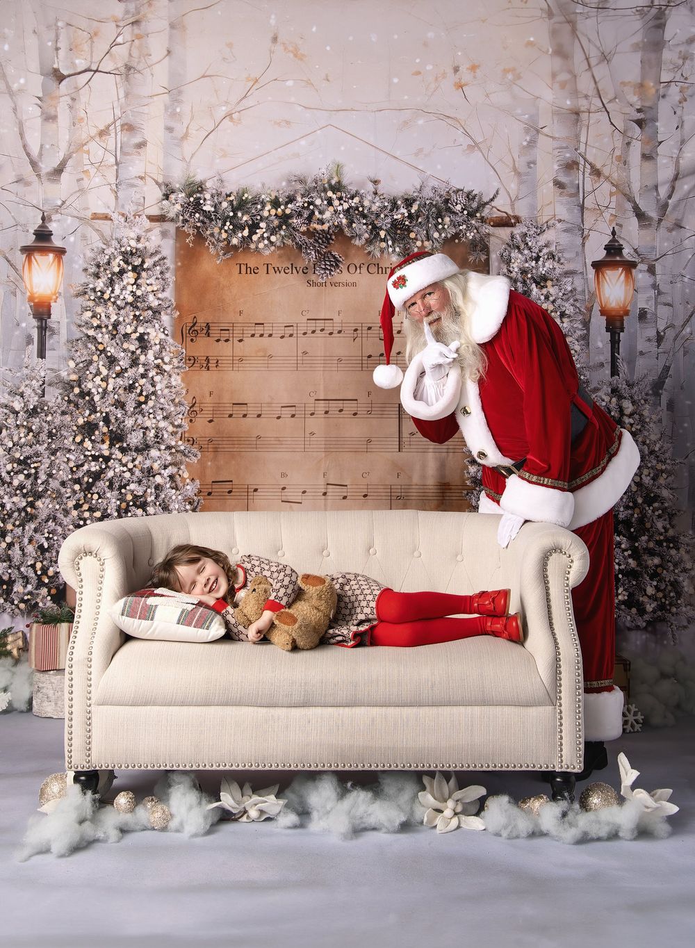 Santa leaning over newborn baby lying on bed during holiday portrait session in Austin studio