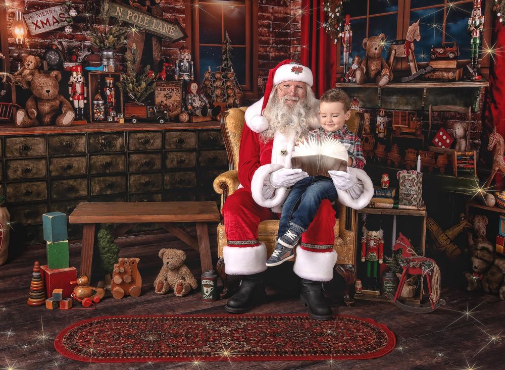 Santa holding child while seated during holiday studio portrait session in Austin photography studio