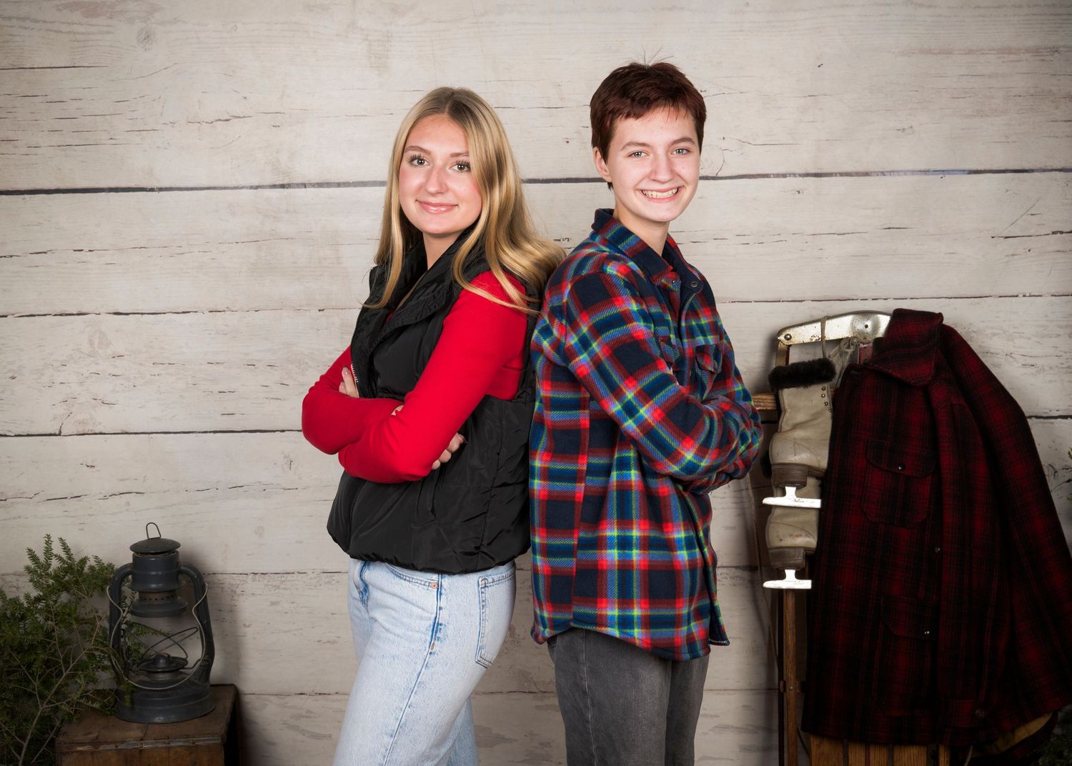 A couple wearing plaid and casual clothing poses together for a series of candid photos against a rustic backdrop.