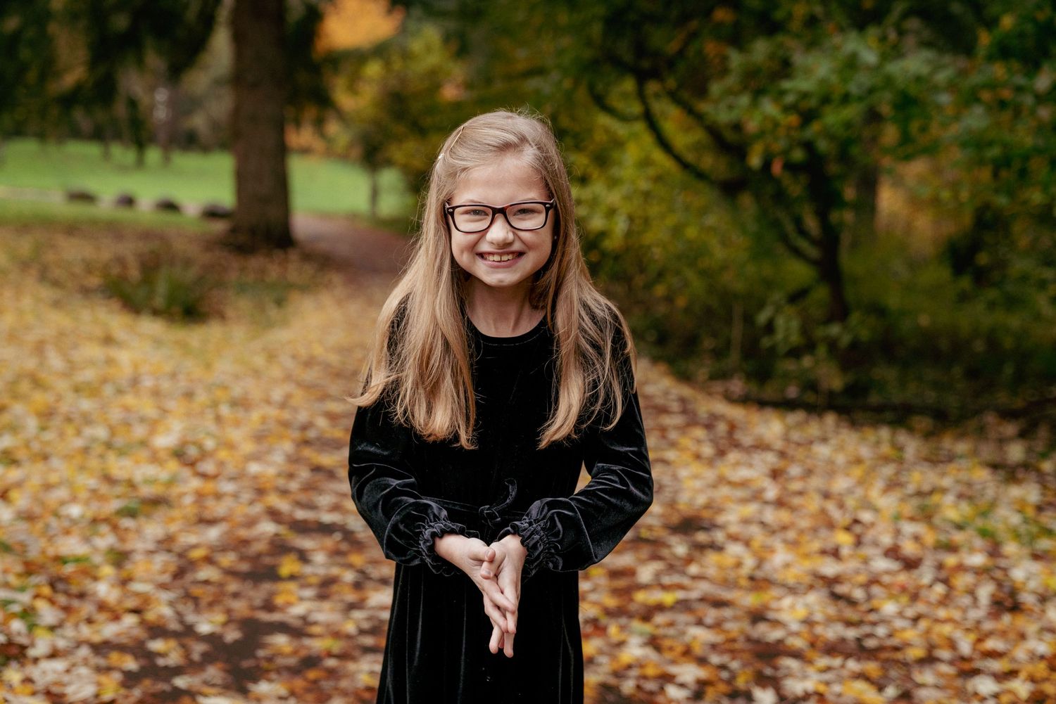 Girl in black velvet dress holding leaves, fall portrait session in Washington State PNW.
