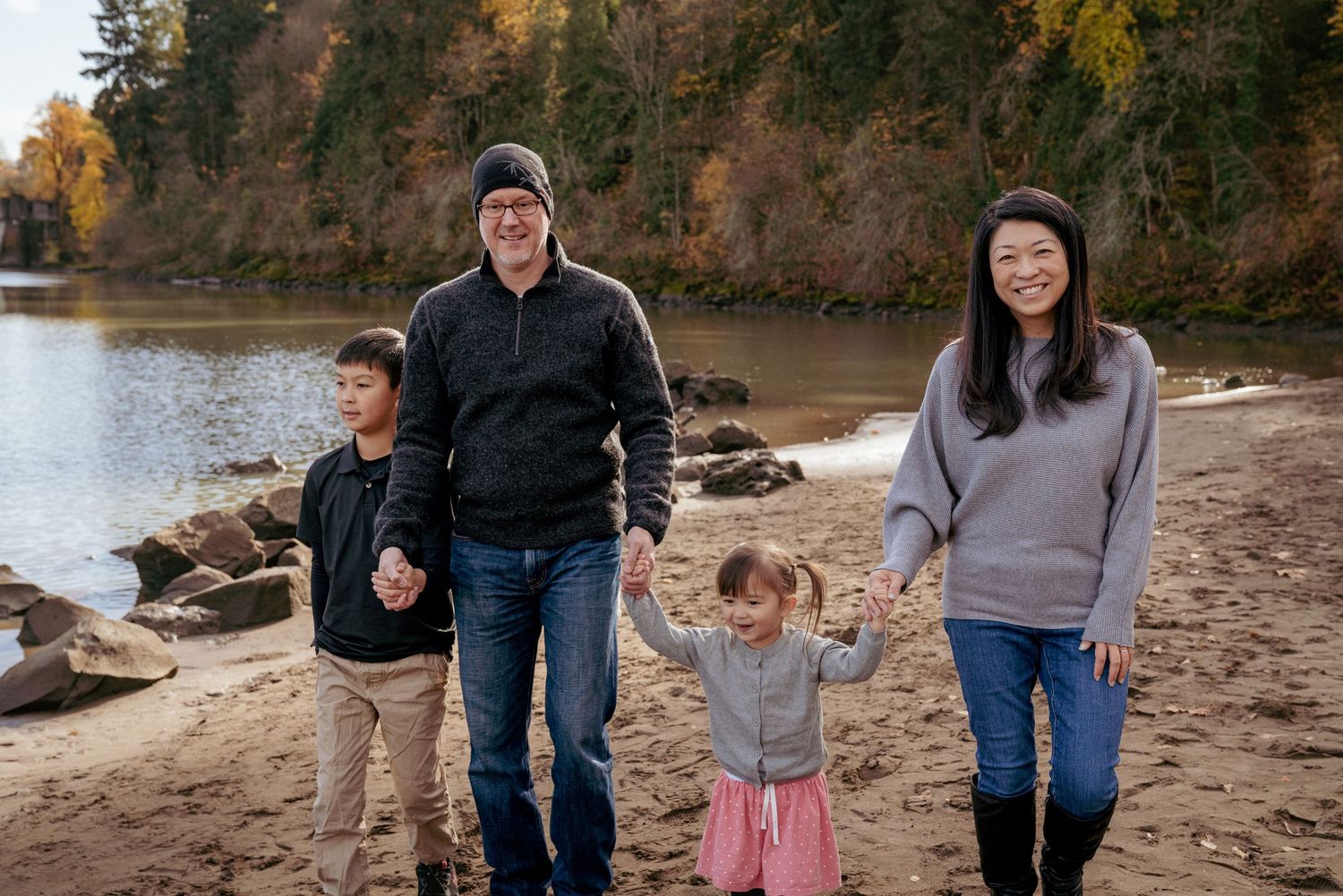 Family of four walking along Willamette River in fall, Oregon State outdoor lifestyle session in the PNW.