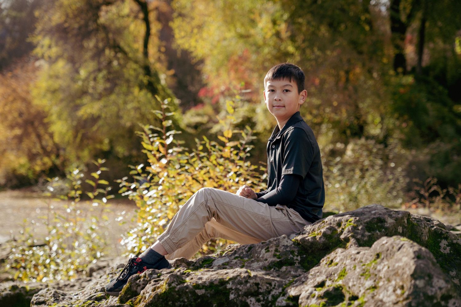 Fall portrait of a boy on a rock in Washington forest, autumn colors, child photography in the Pacific Northwest.