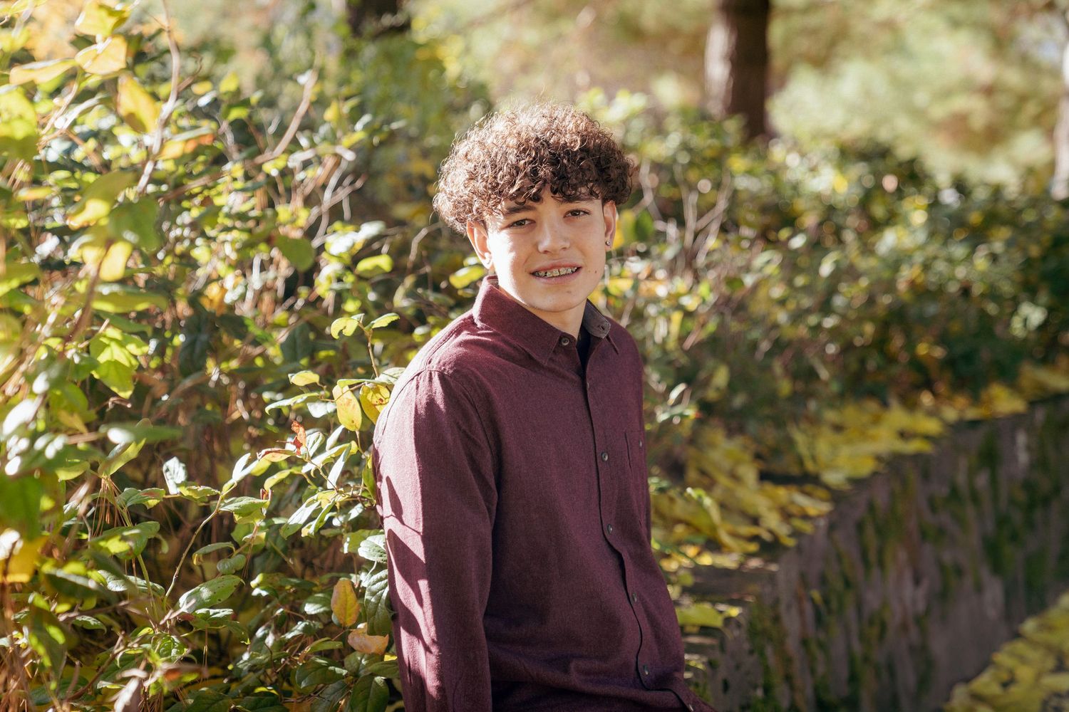 Natural portrait of curly-haired teen boy among fall plants, Portland metro area, Pacific Northwest photography.