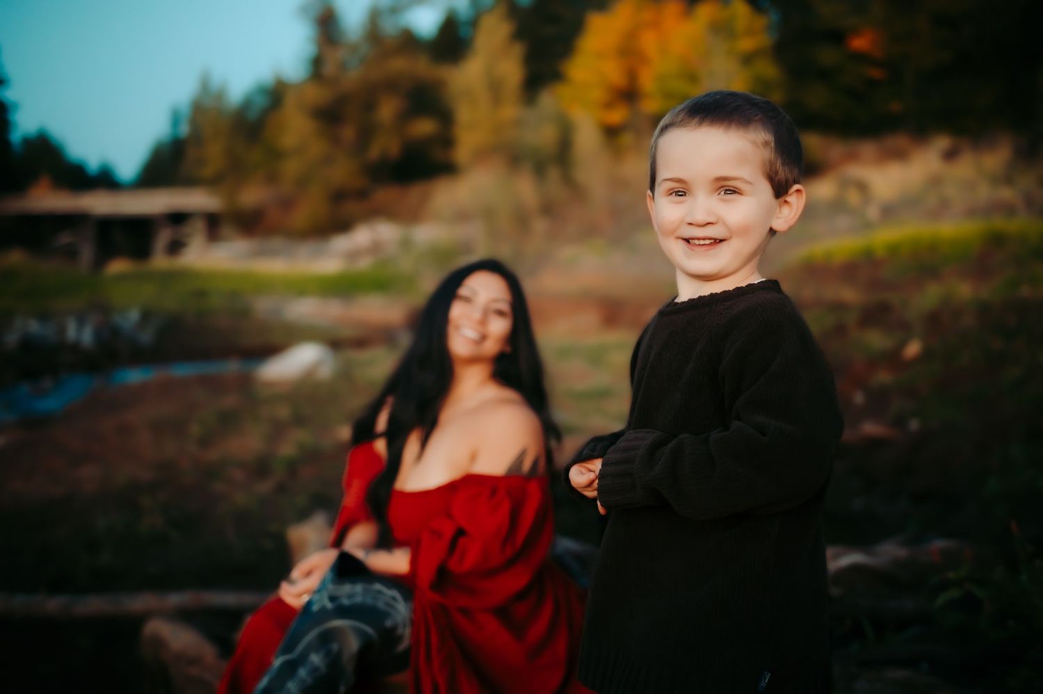 Family silhouetted against sunset sky during outdoor photo session.
