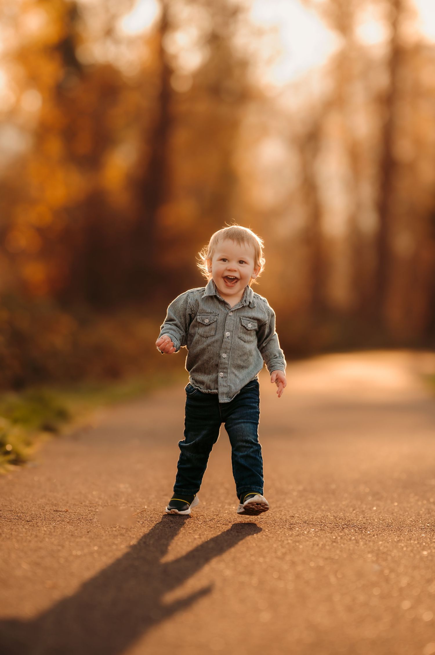 Small child runs along sunlit path during golden hour.