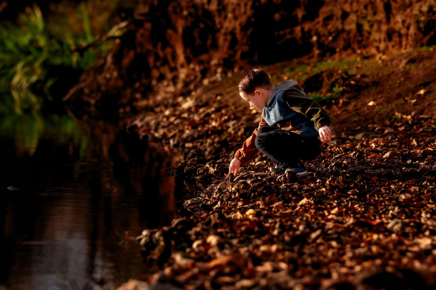 Close-up of feet walking through autumn leaves on forest ground.