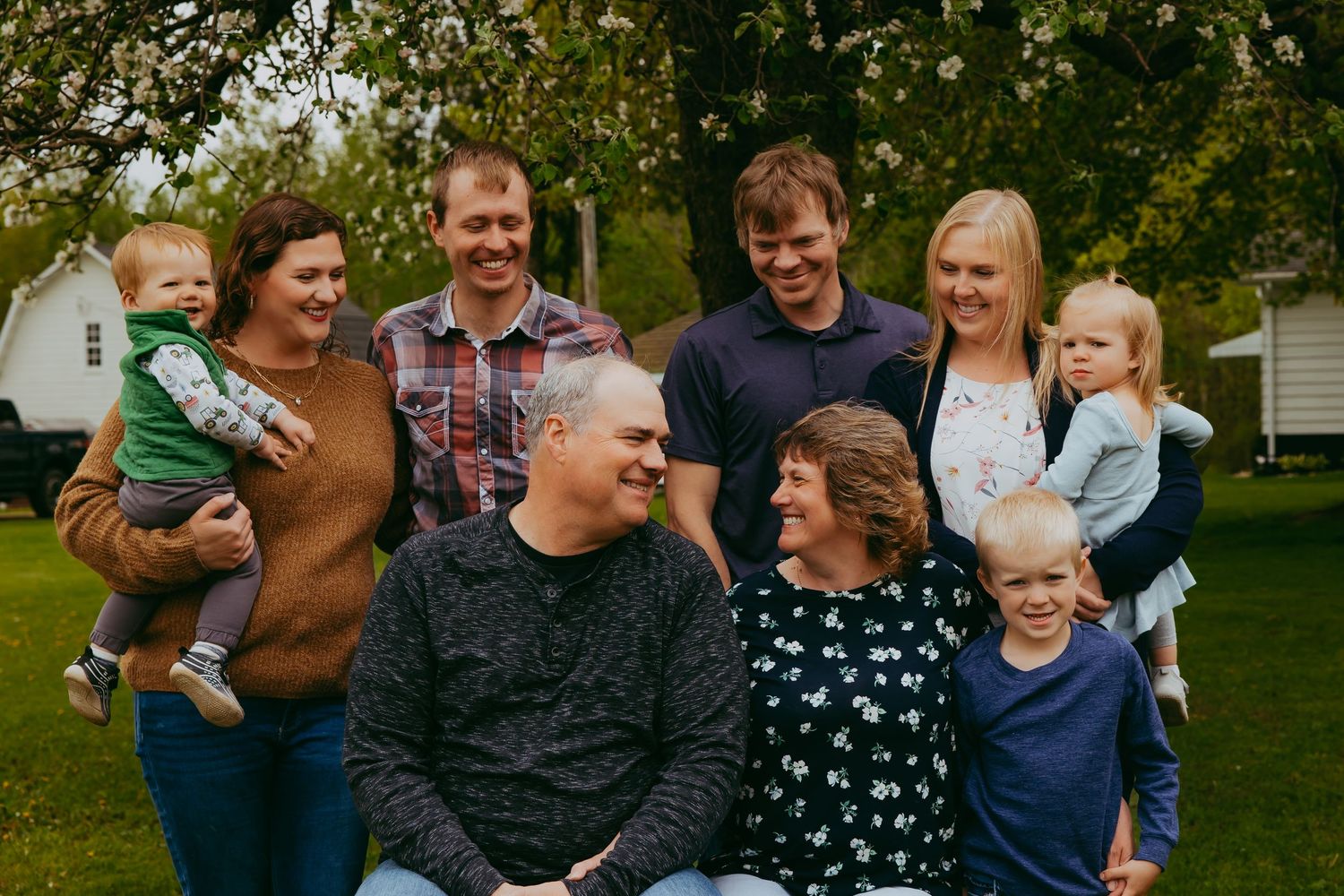 Large group photo of family and friends gathered outdoors on summer day.
