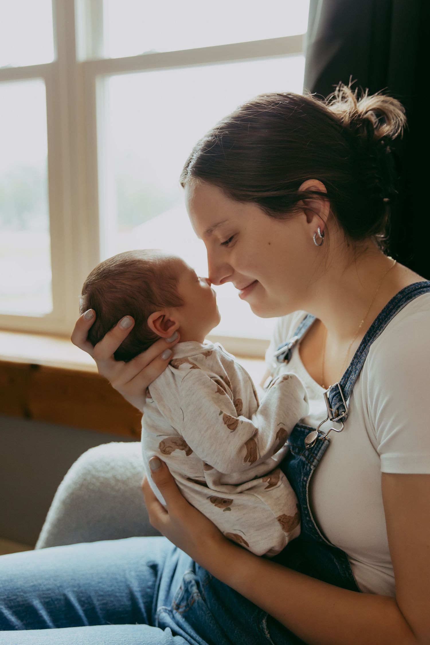 Family shares intimate moment with newborn baby in cozy indoor setting.