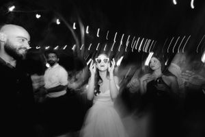Black and white photo of a bride dancing at a wedding reception with motion blur and lights creating a dreamy atmosphere.