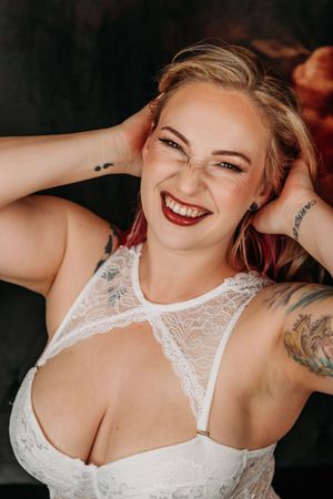 A series of boudoir photos featuring a person in white lace lingerie posing against a dark background. Intimate Boudoir Photographey