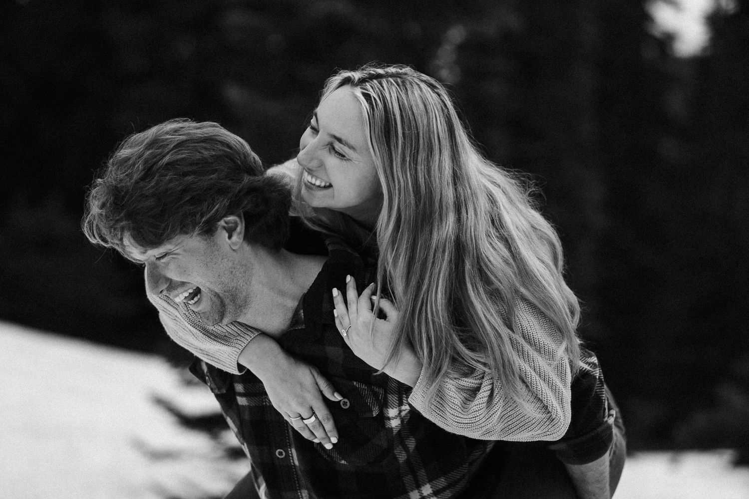 Candid black and white photograph capturing a joyful moment between a duo showing genuine laughter and emotion.