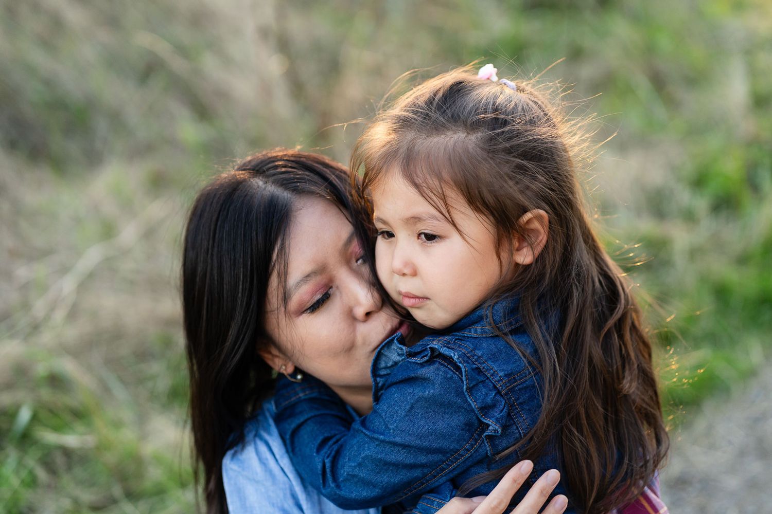 Mom cuddling her daughter who is sad.