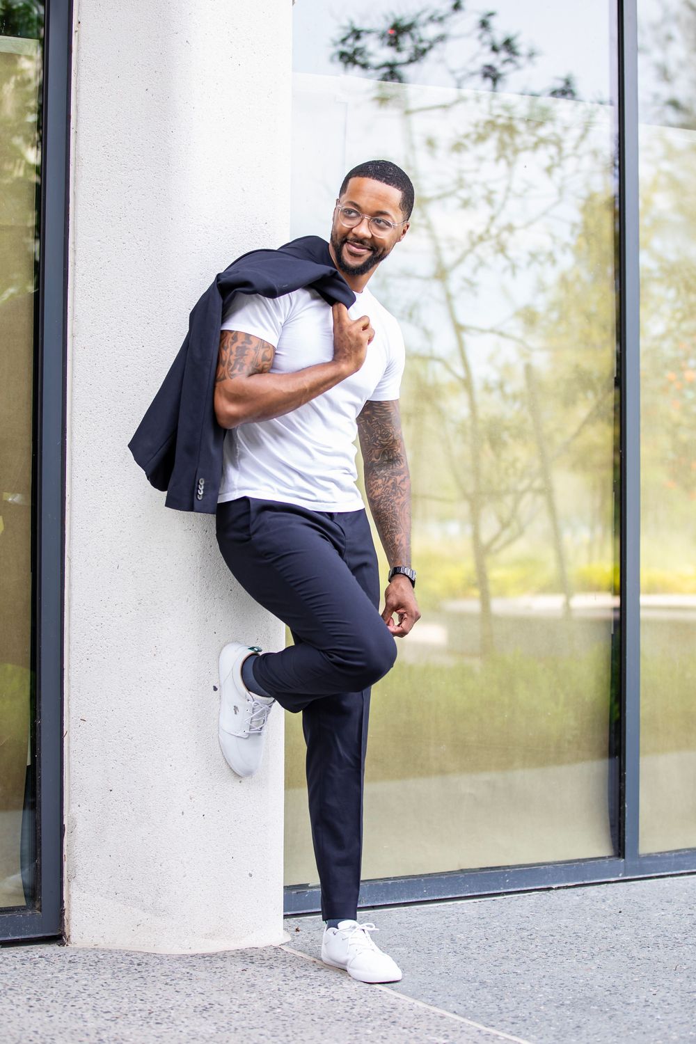 Athletic poses shown against modern building wall in business casual attire.
