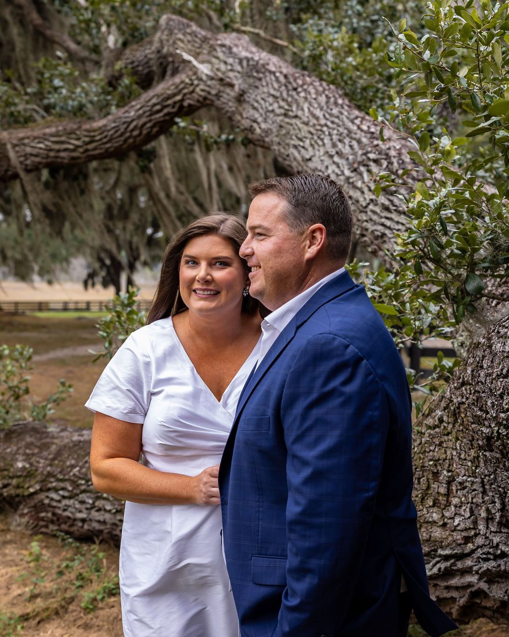 Natural outdoor couple photos taken under large oak tree branches.