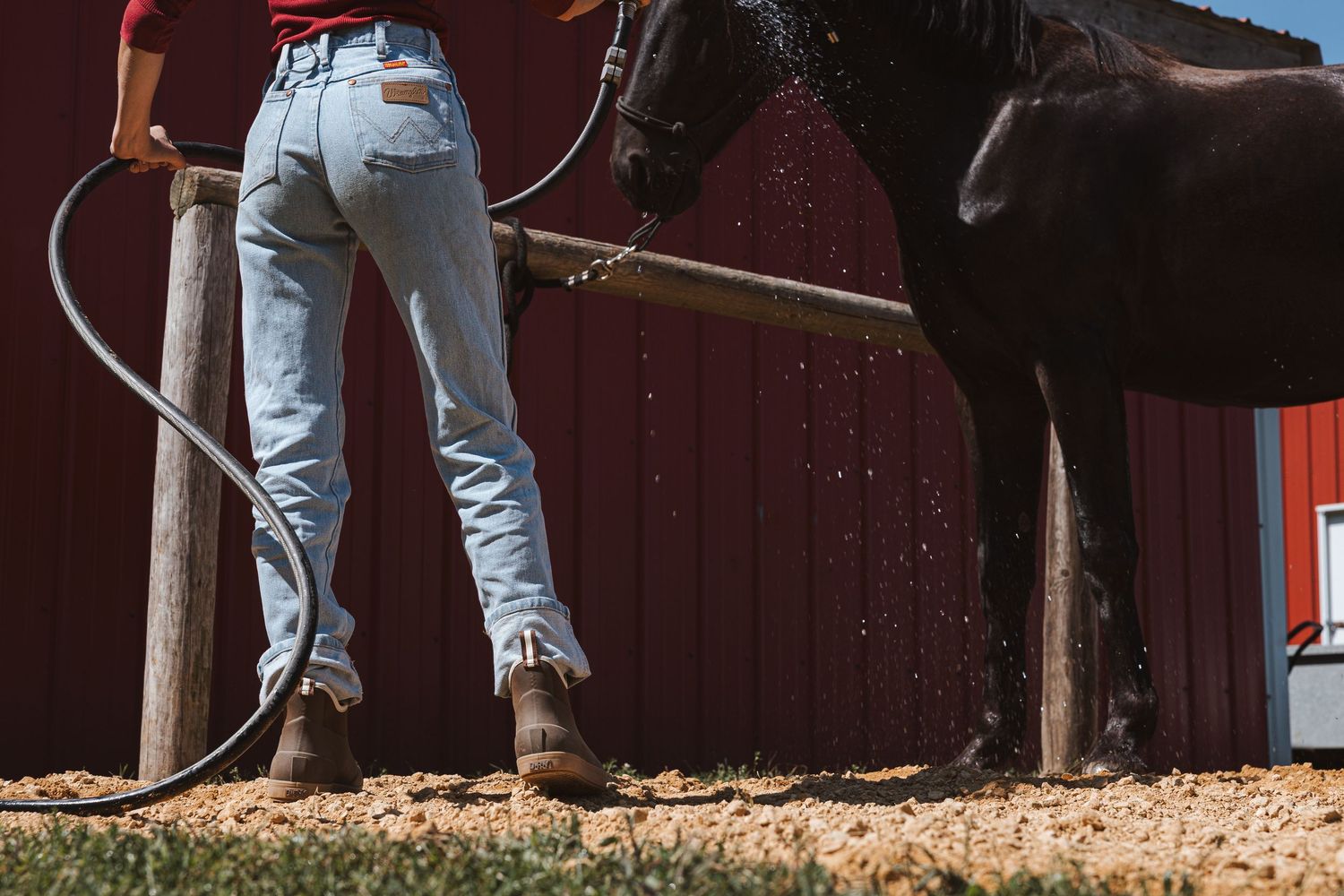 Blue jeans with visible rips and wear shown from different angles on a wooden deck surface in natural lighting.