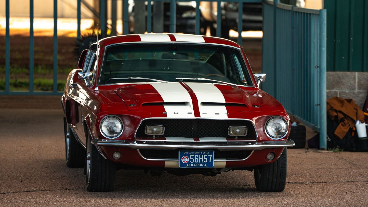 Row of vintage Ford Mustang cars in red and white colors displayed at a classic car show.