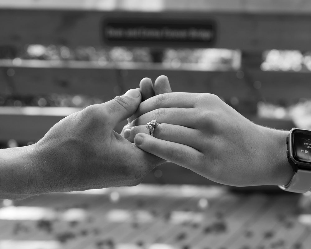 Two hands reaching towards each other with soft lighting in black and white, reminiscent of Michelangelo's Creation of Adam.