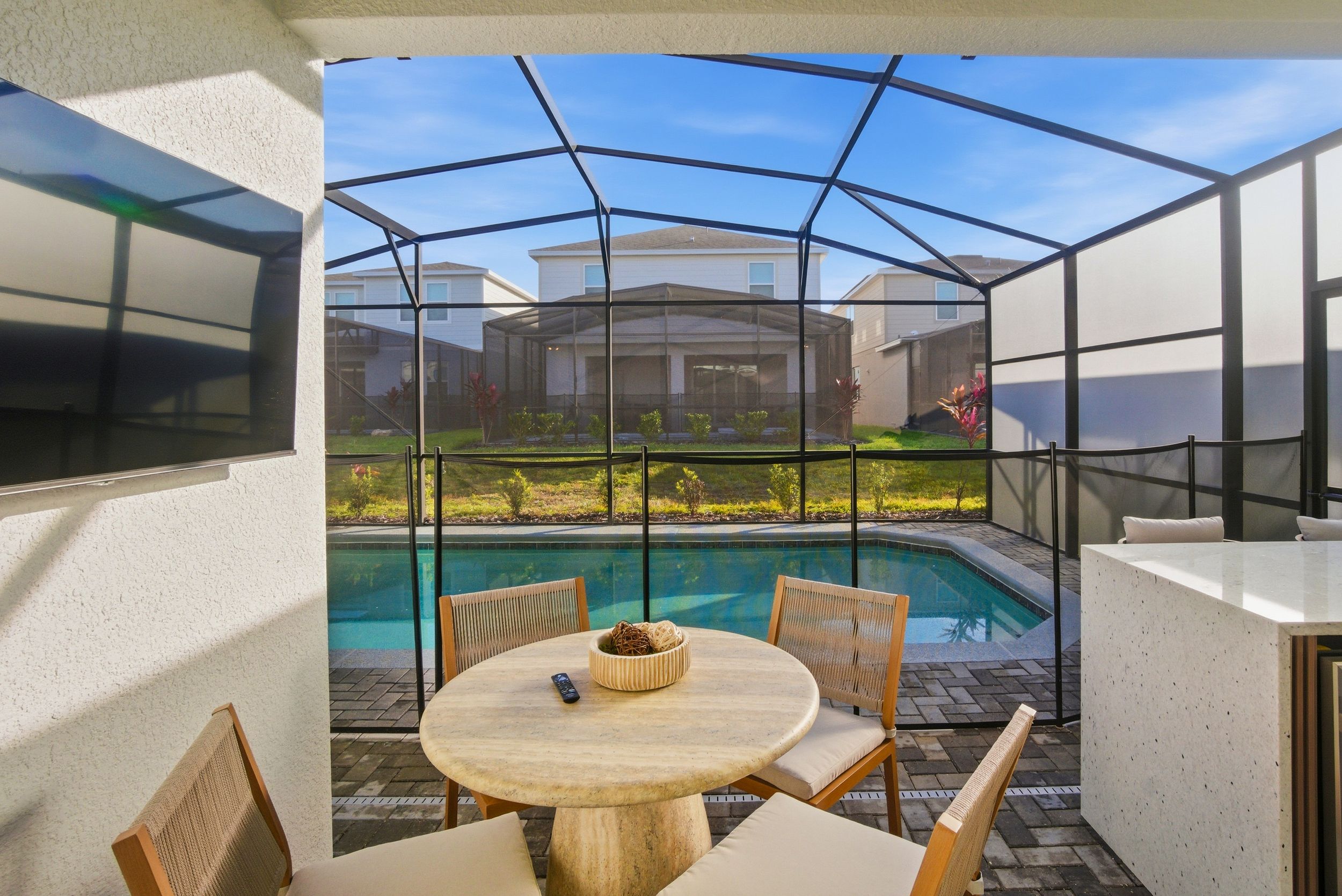 Screened lanai with pool and patio furniture offers a relaxing outdoor living space in a Florida home.