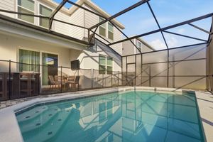 Covered swimming pool with glass enclosure and screened walls offering year-round swimming in a residential setting.