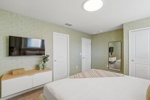 Panoramic view of an empty basement room with white doors, recessed lighting, and light green painted walls.