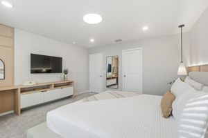 Modern apartment interior features white walls, recessed lighting, and hardwood floors in an open concept layout.