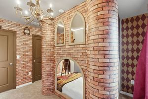 Exposed brick walls and decorative wallpaper create a rustic charm in this modern bathroom interior design.
