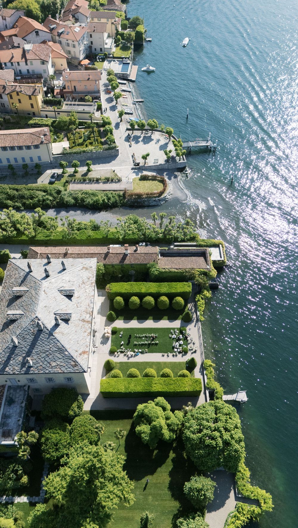 Aerial view of a luxurious waterfront villa with manicured gardens on Lake Como.
