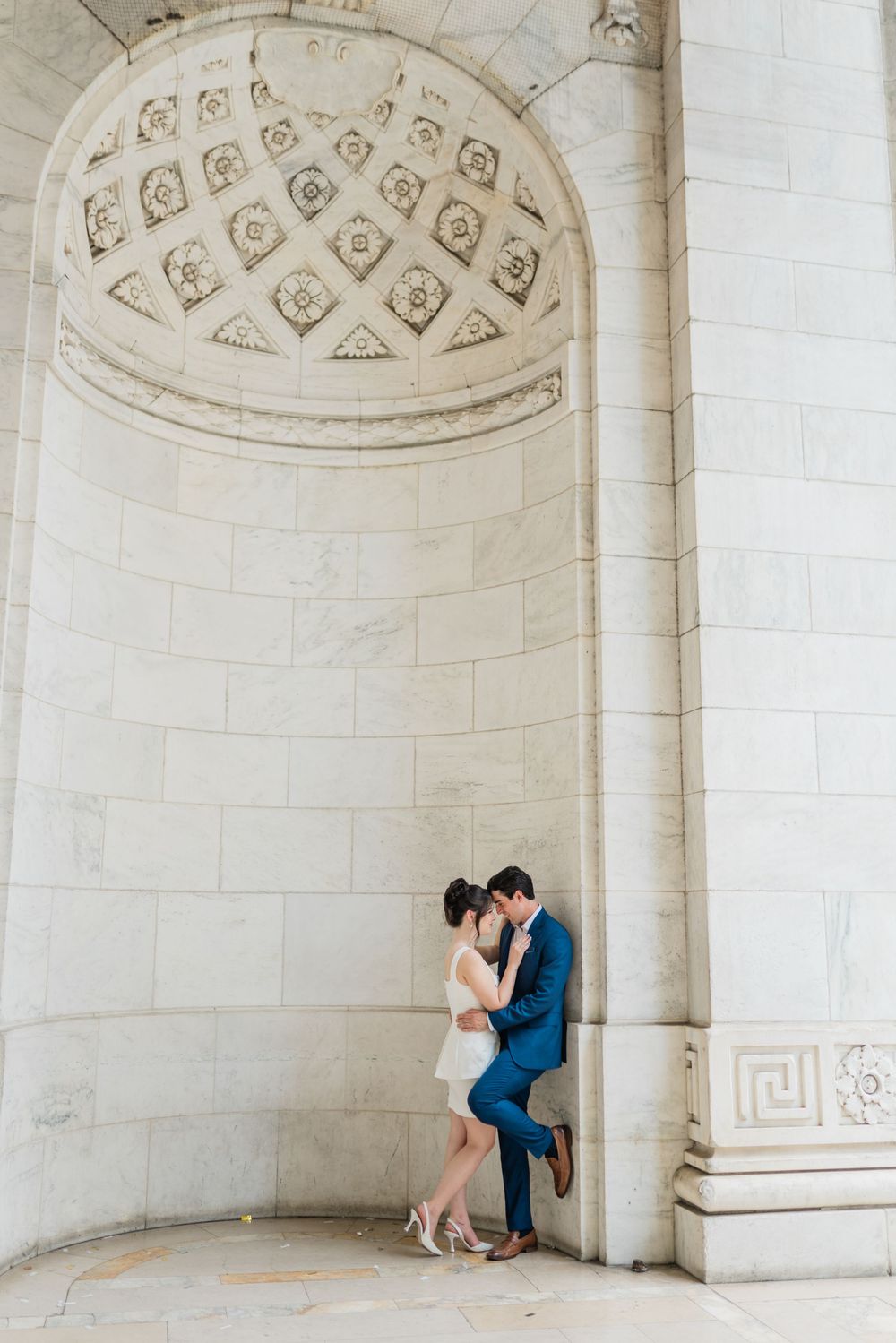 Couple shares romantic moment under ornate domed alcove with geometric patterns.