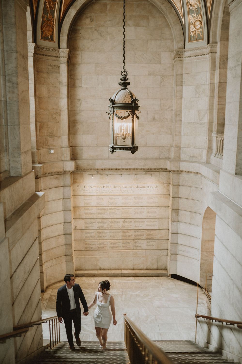 Historic stone stairwell with hanging lantern and arched architectural details.
