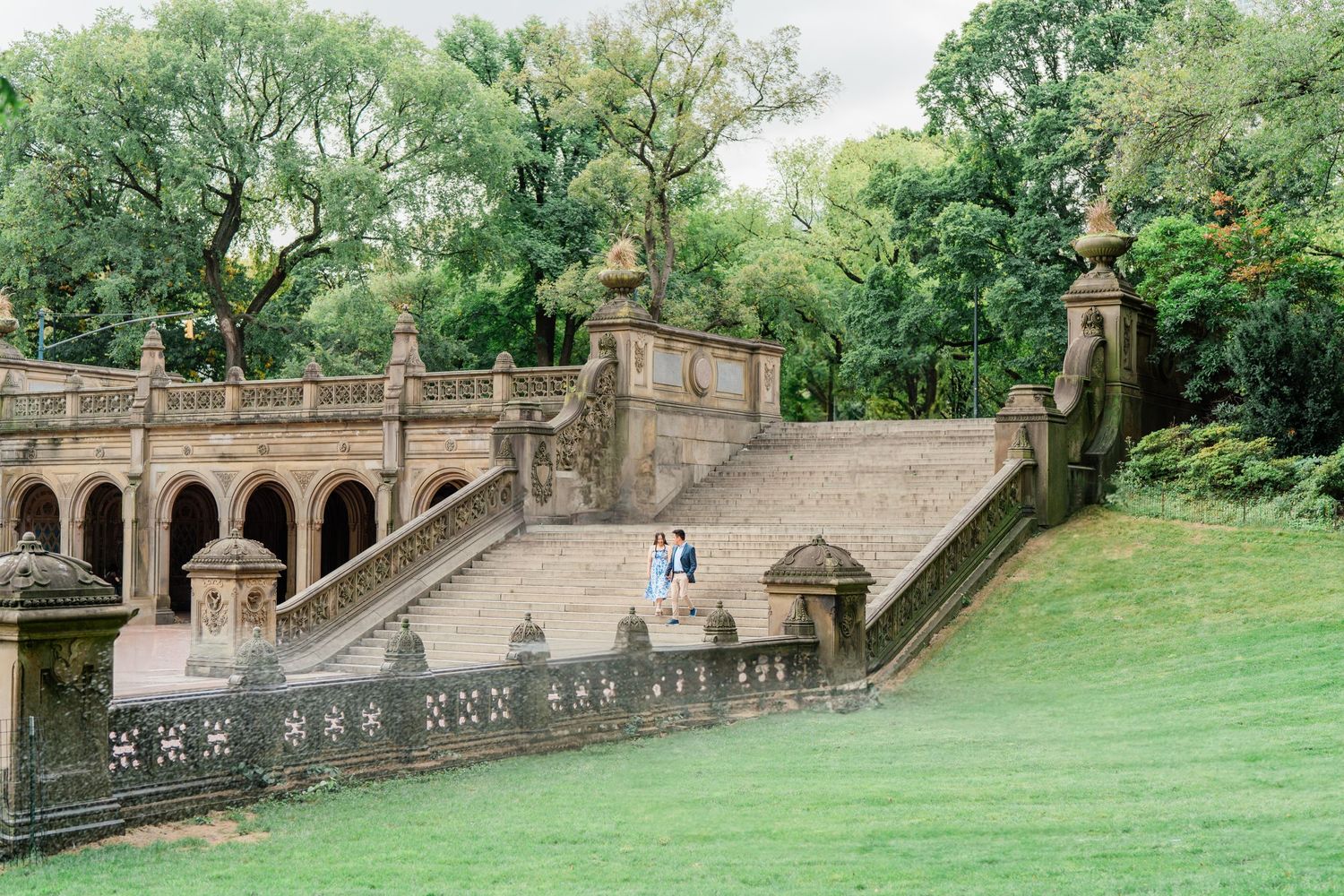 Panoramic view of Central Park's stone terraces and lush greenery on an overcast day.