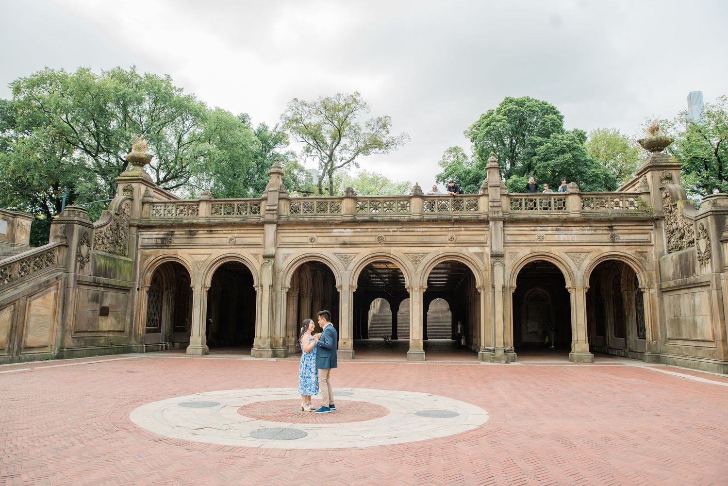 Panoramic view of a historic stone terrace with ornate arches and columns in a park setting.