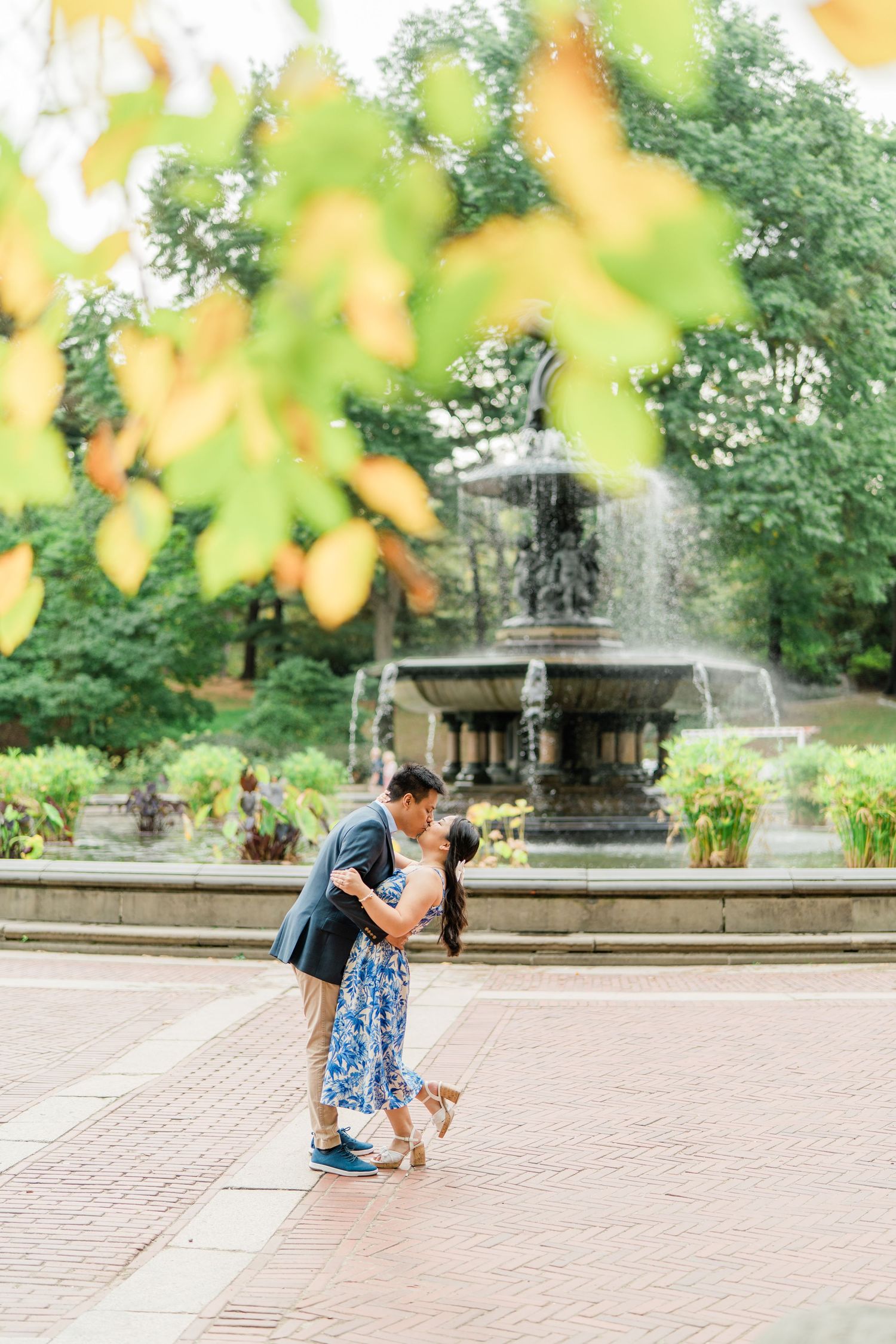 Brick plaza with fountain and autumn leaves framing the scene.