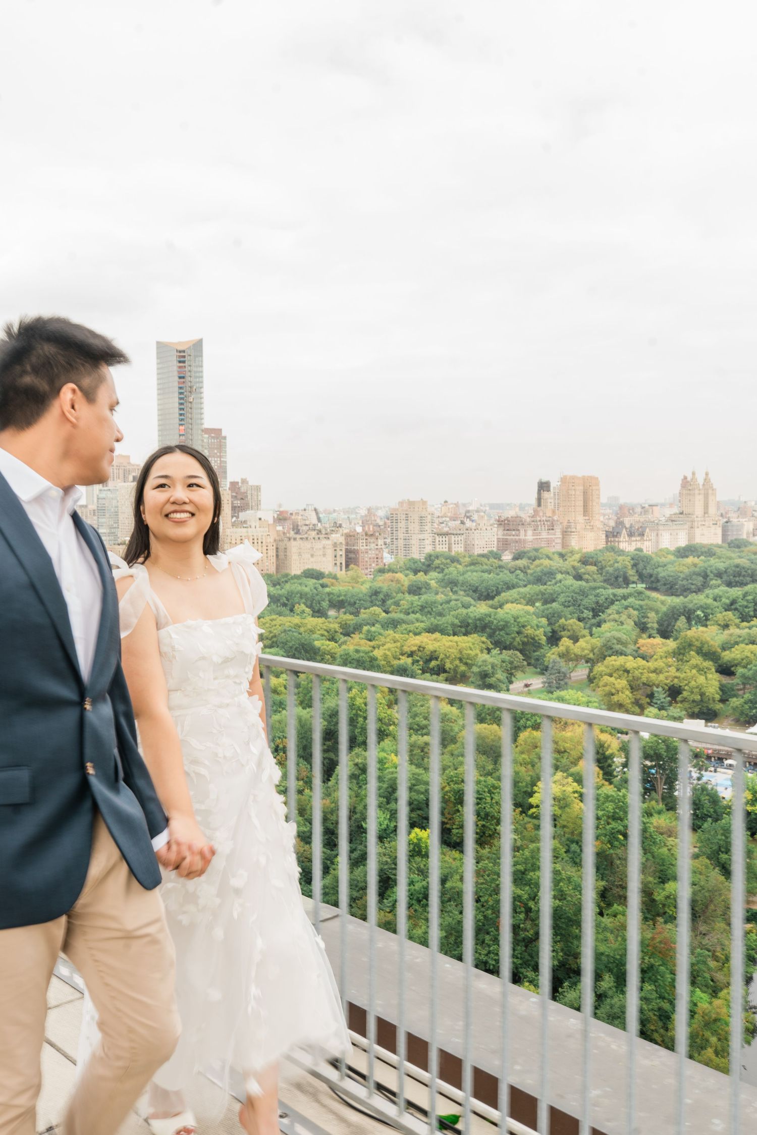 Couple enjoying views of Central Park from a balcony overlooking the Manhattan landscape.