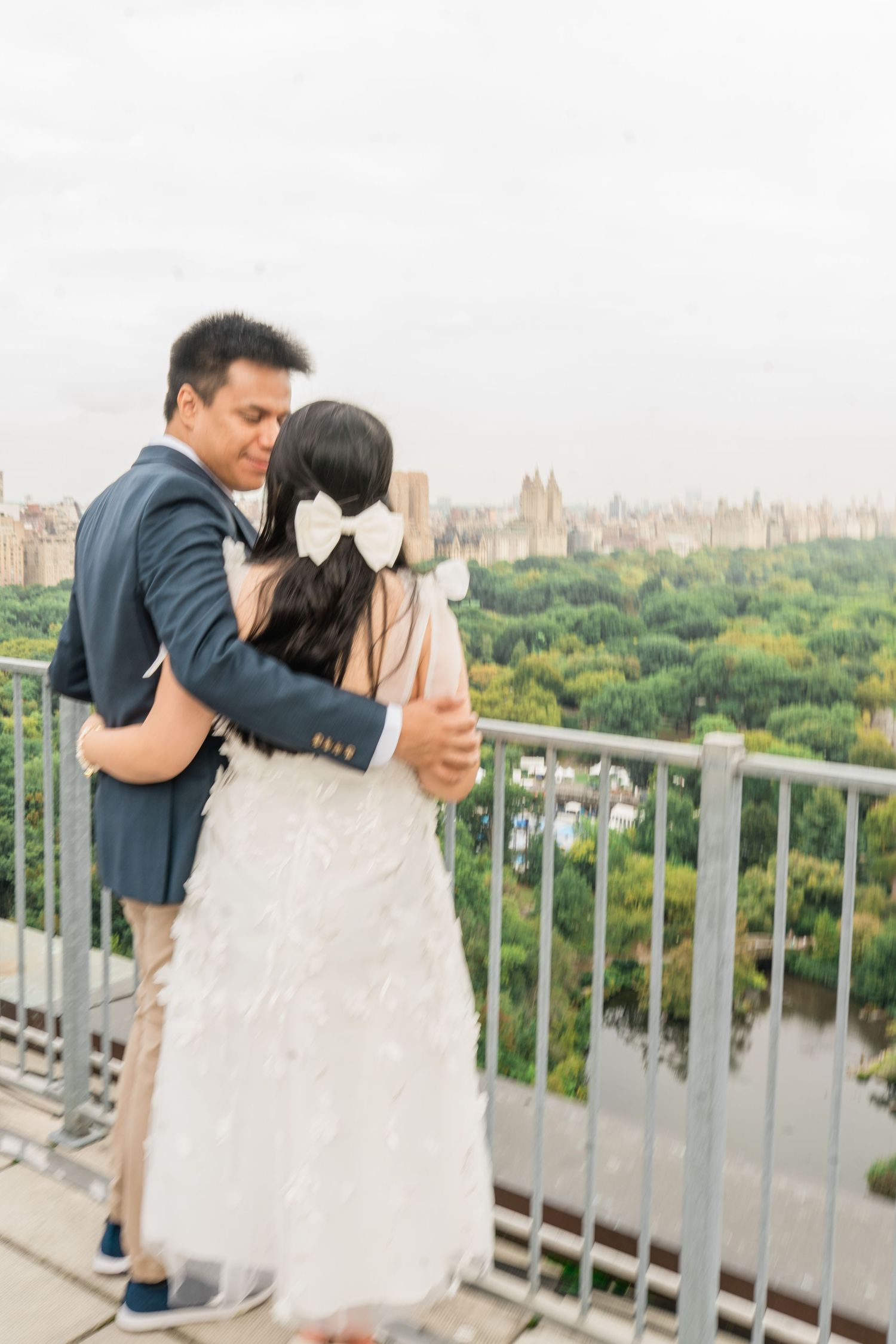 Playful dance moves on a rooftop terrace with Central Park's greenery in the background.