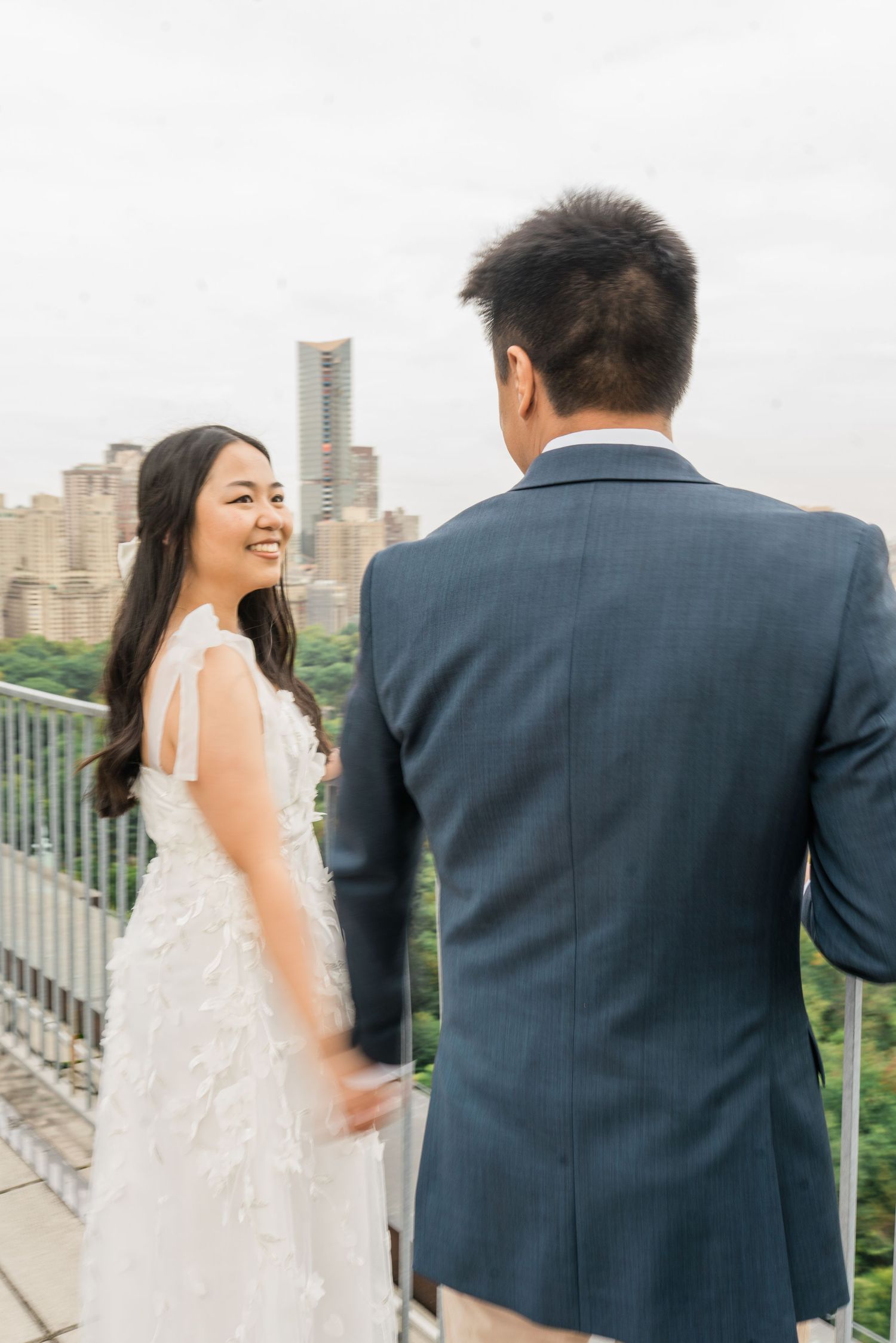 Candid moments captured on a Manhattan rooftop with cityscape views.