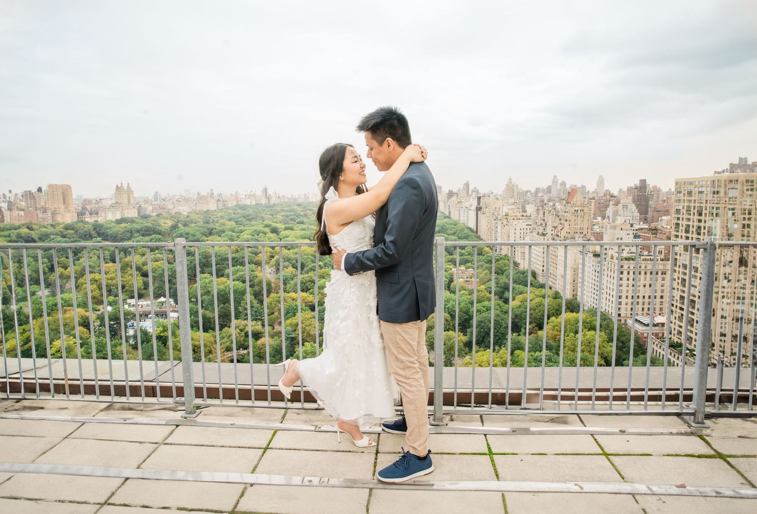 Couple sharing a romantic moment on a rooftop terrace overlooking Central Park and the Manhattan skyline.