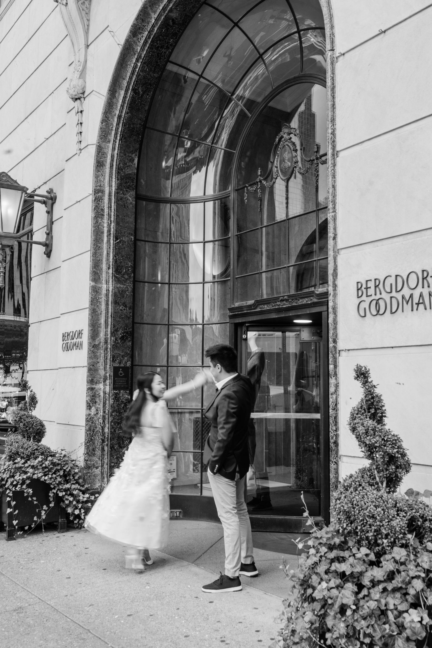 Black and white sequence showing a couple outside an elegant building entrance with arched windows.