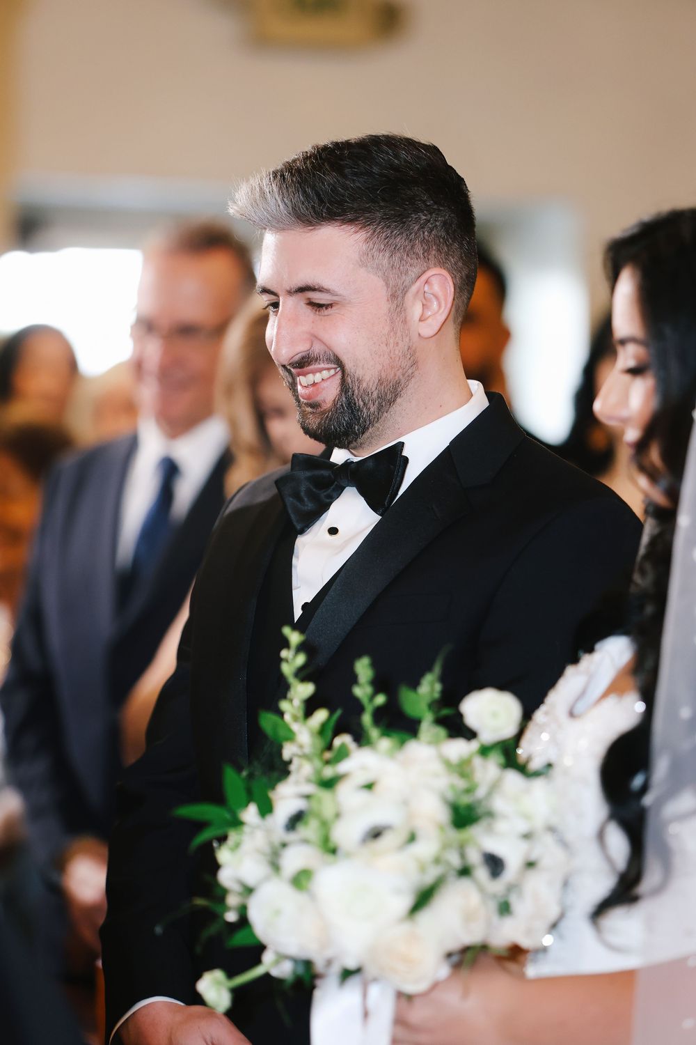 Close-up view of a wedding ceremony showing various scenes with elegant white floral arrangements and formal attire.