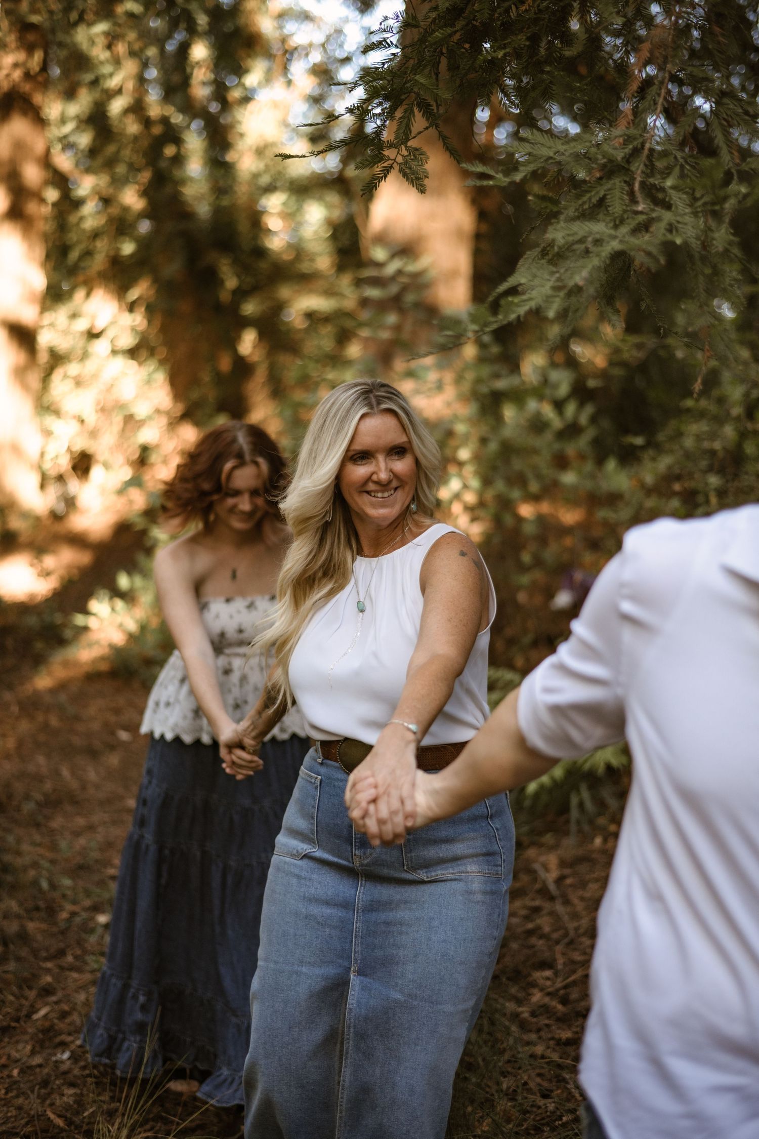 Casual couple photoshoot among trees in natural outdoor setting.