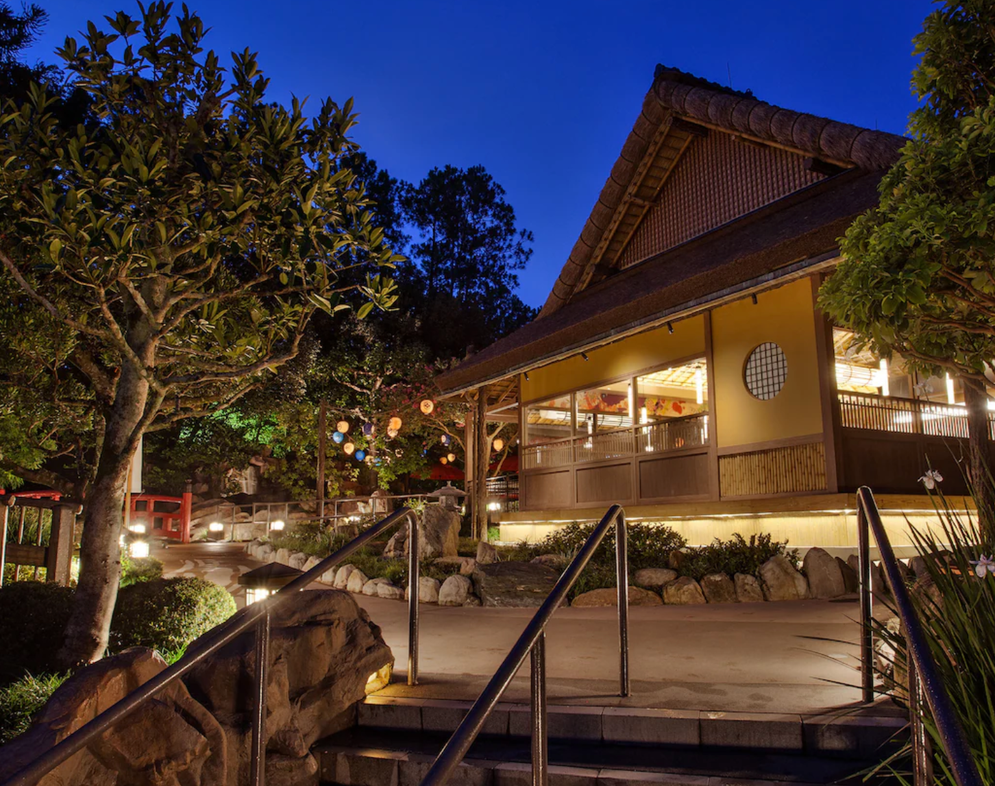 Traditional Japanese restaurant exterior illuminated at night with wooden architecture.