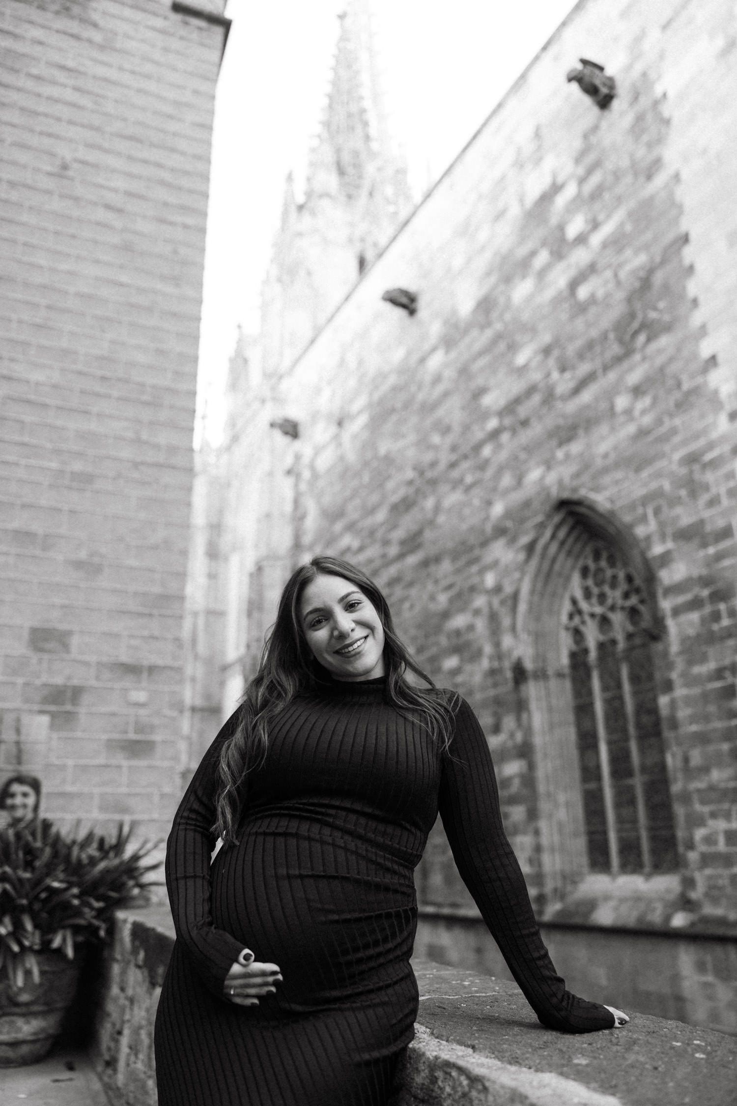 Maternity photoshoot against weathered stone walls and Gothic architecture.
