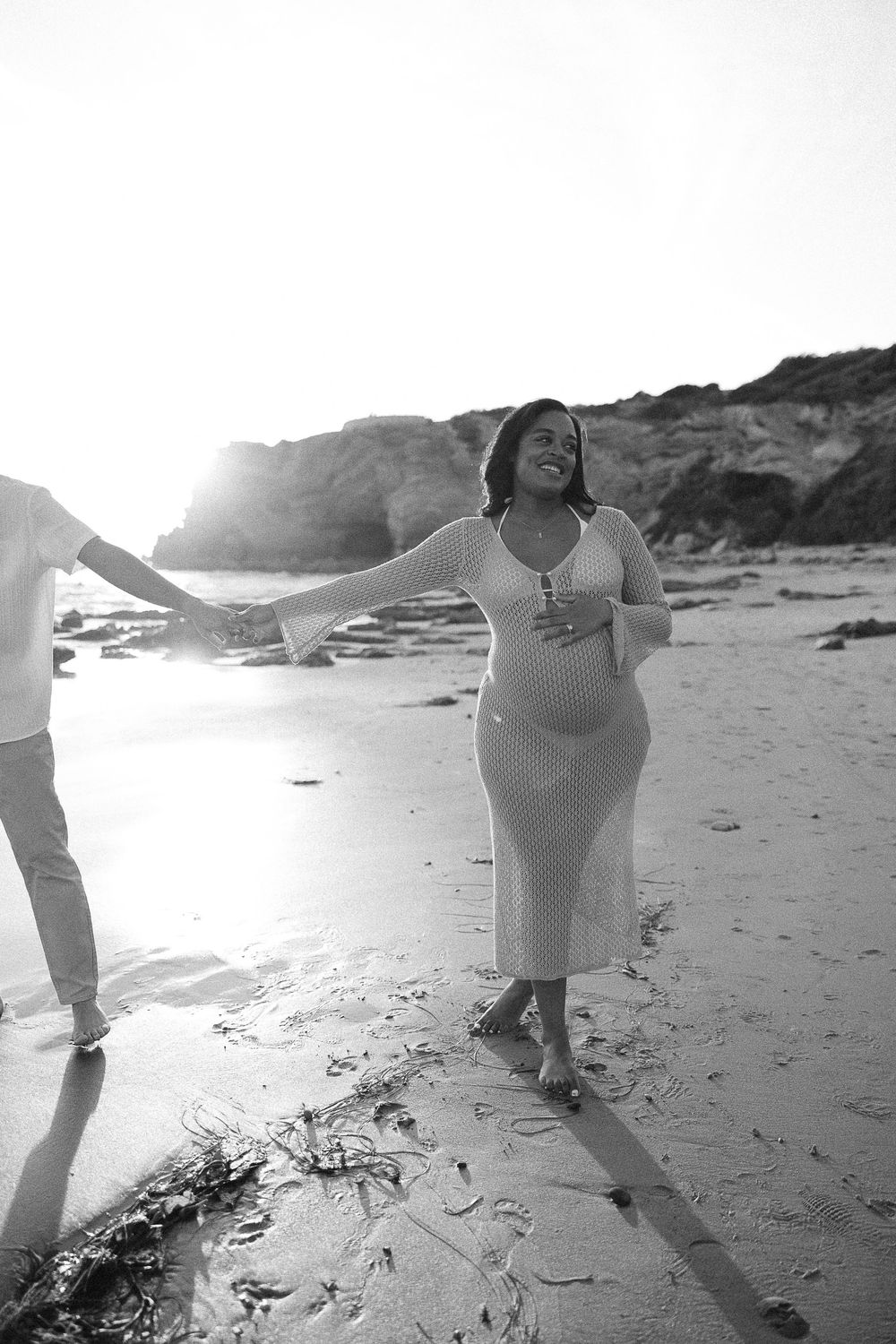 Black and white photo sequence showing a person in white clothing dancing gracefully on a beach at sunset.