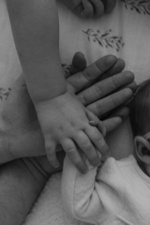 Black and white close-up images showing hands performing a gentle massage technique on a foot.
