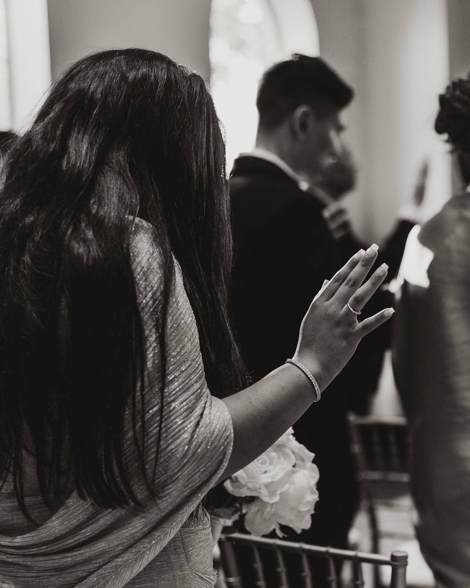 black and white wedding photo of family praying over the bride and groom at a wedding ceremony. christian wedding photographer. Maitland FL