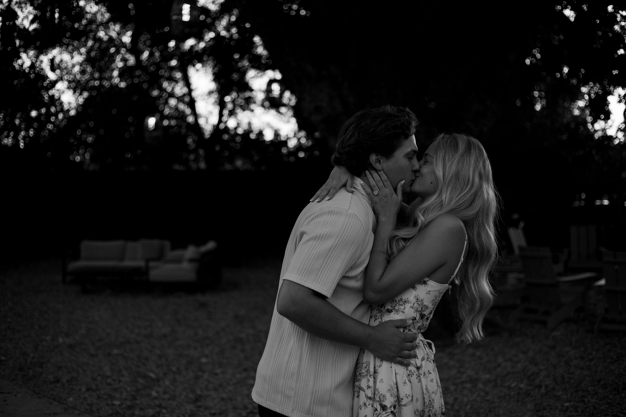 A romantic couple embraces in a black and white outdoor photo series showing tender moments between them.
