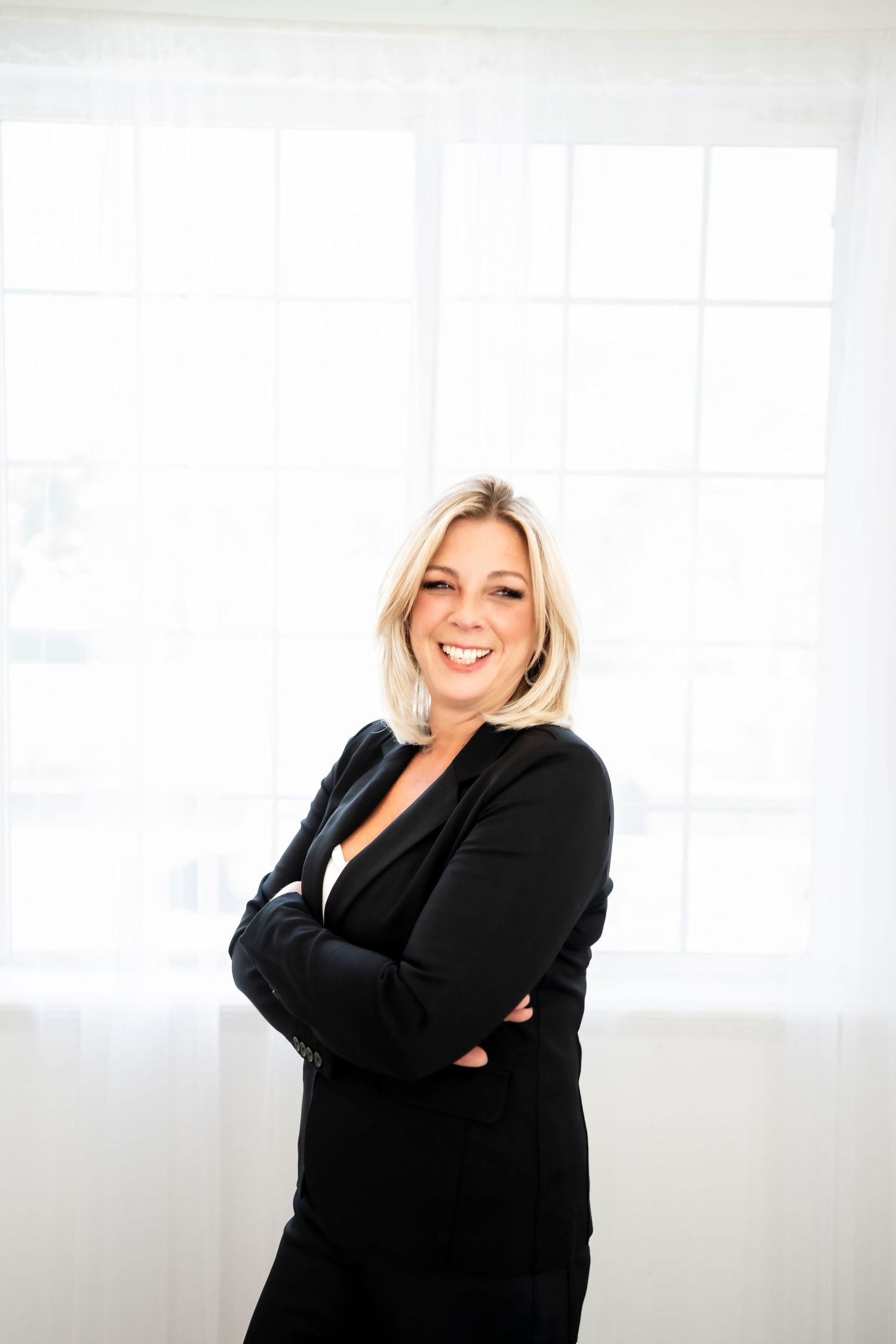 Professional portrait session in bright white studio space with business attire.